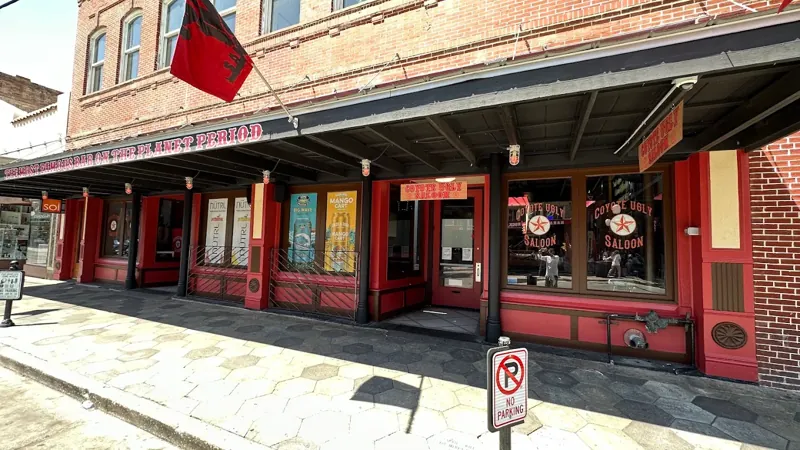 Historic brick storefront with a red-painted facade, awning, and street-level windows.