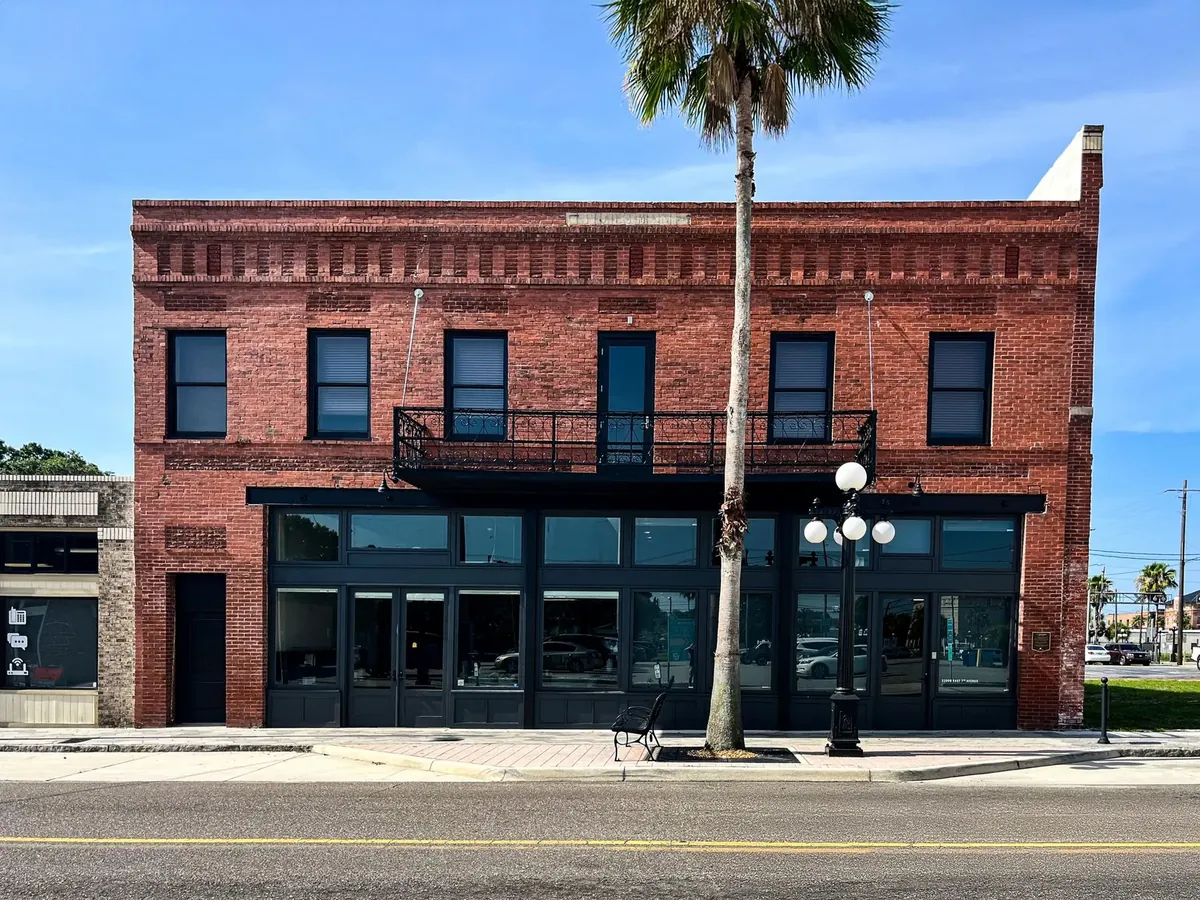 Exterior commercial painting on historic brick building in Ybor City Tampa with black trim and balcony railings